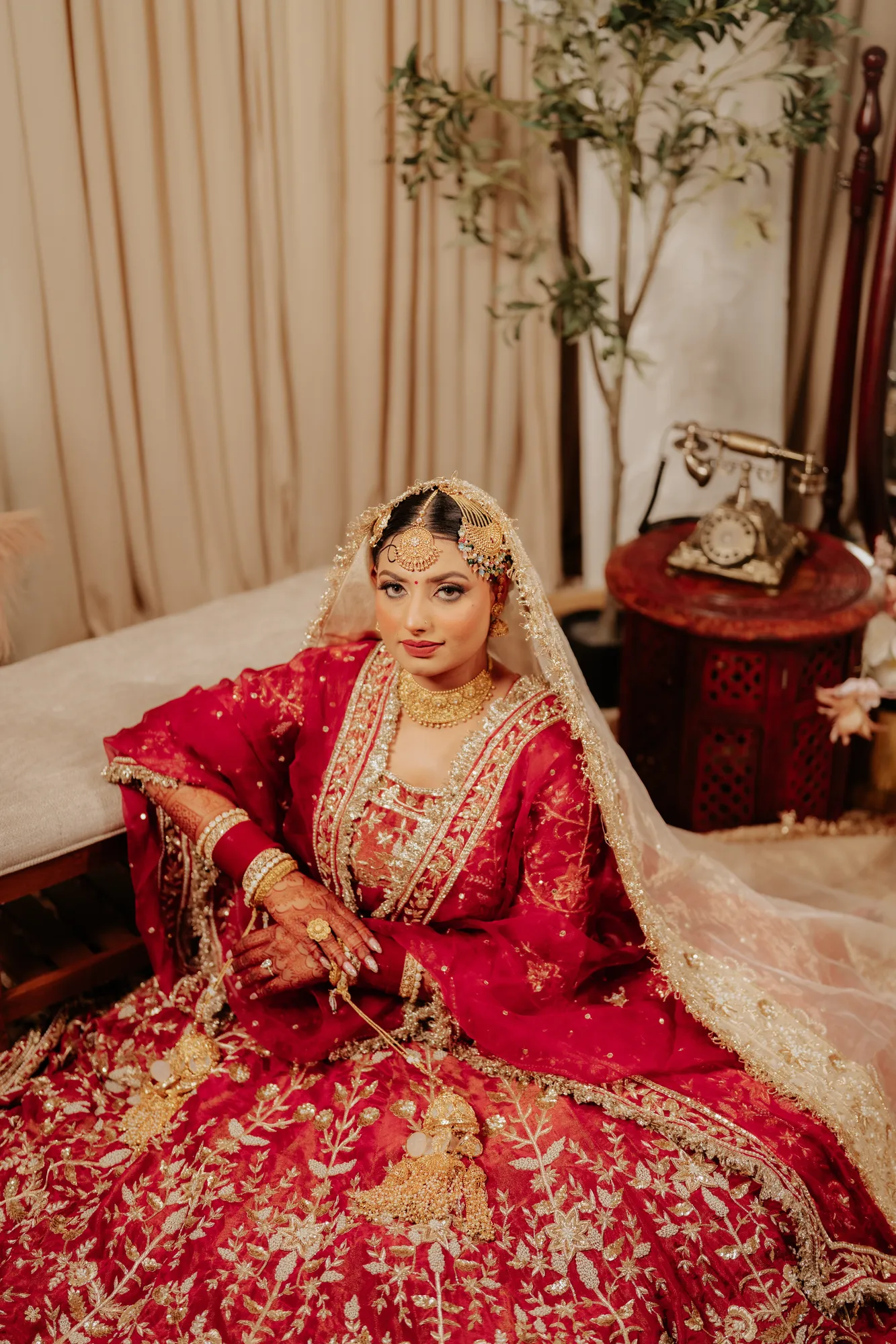 Bride seated in an embroidered red wedding outfit