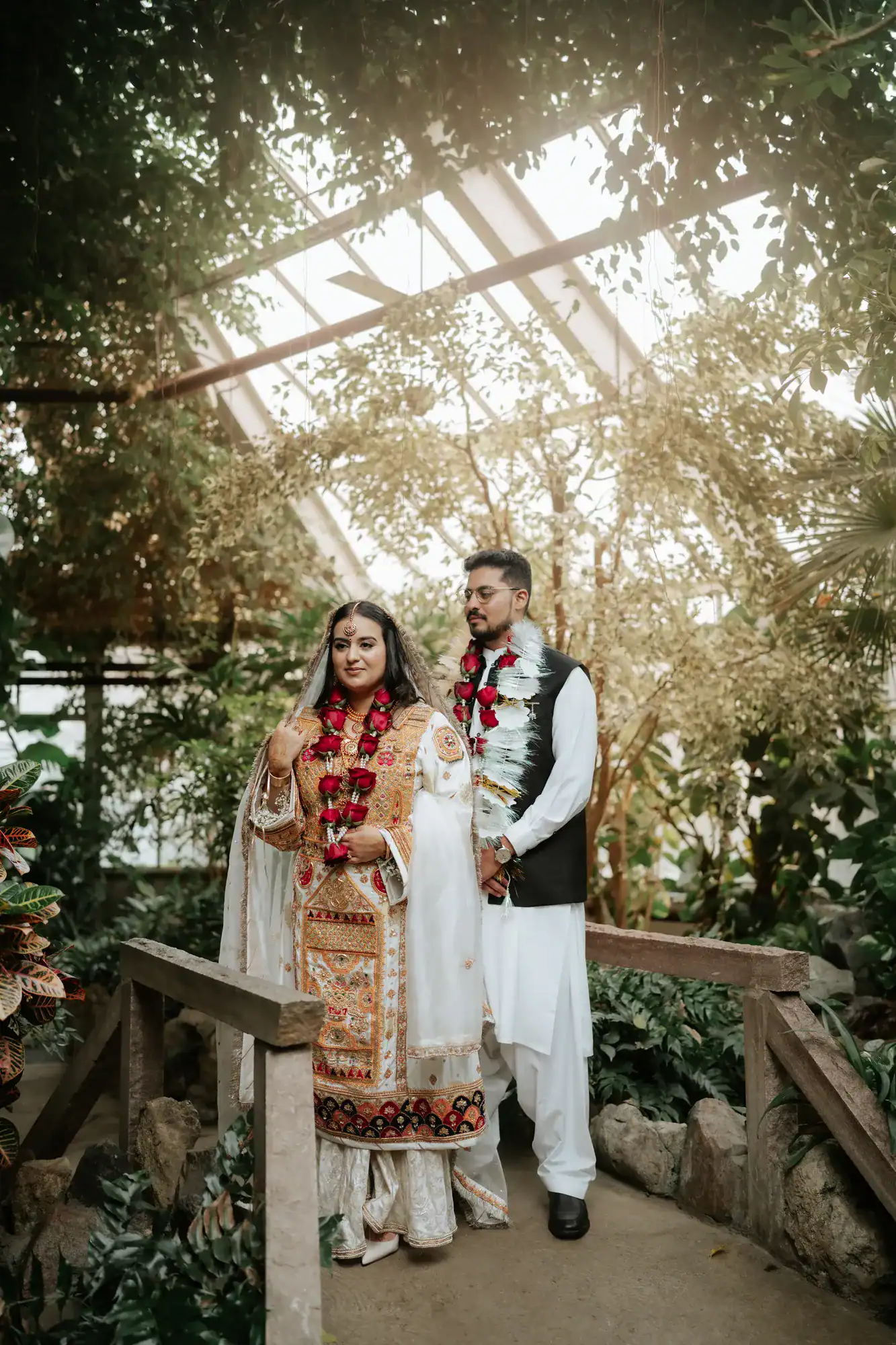 Newlyweds standing together in a greenhouse