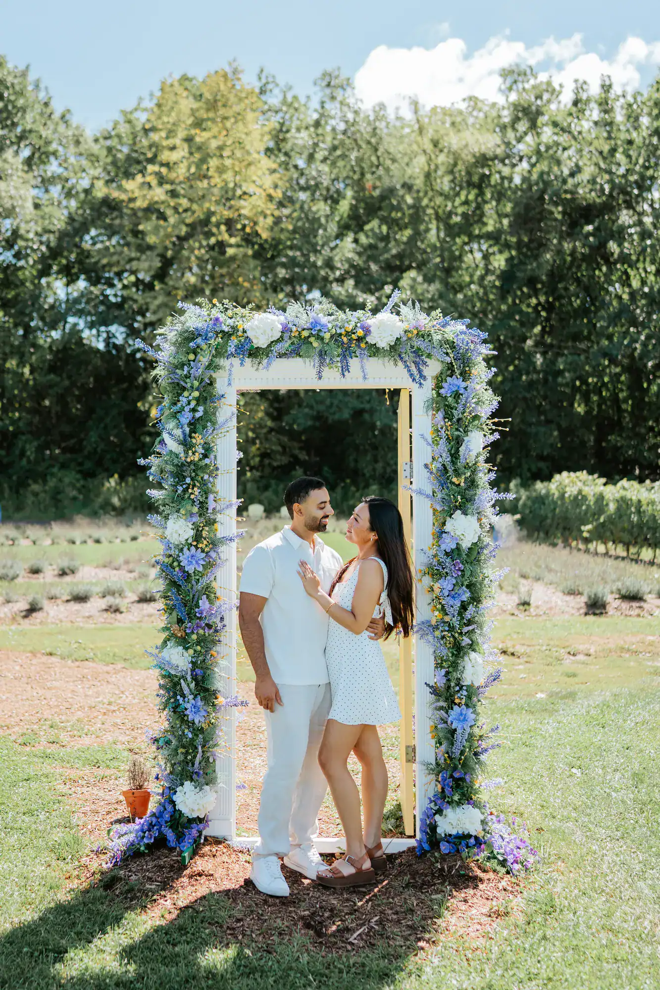 Couple beneath a floral arch in a garden